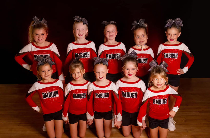 Iowa Ambush Cheer team posing in red and white uniforms